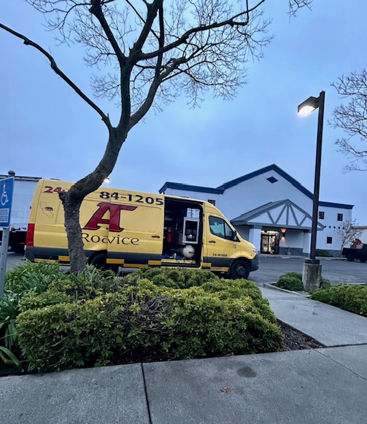 Yellow A&T Road Service Sprinter with side door open at a job