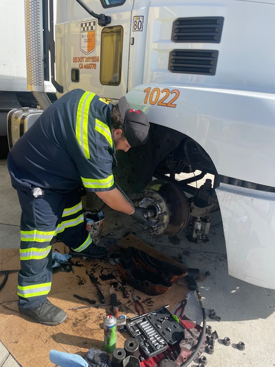 A&T technician performing a wheel-hub repair on a white semi